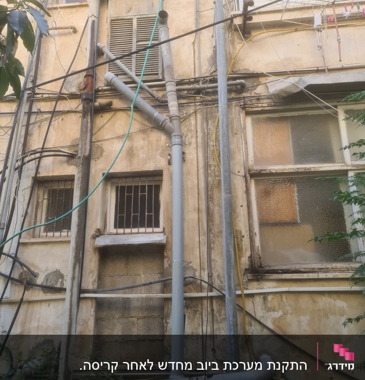 צינורות ביוב חיצוניים מחוברים לקיר בניין ישן